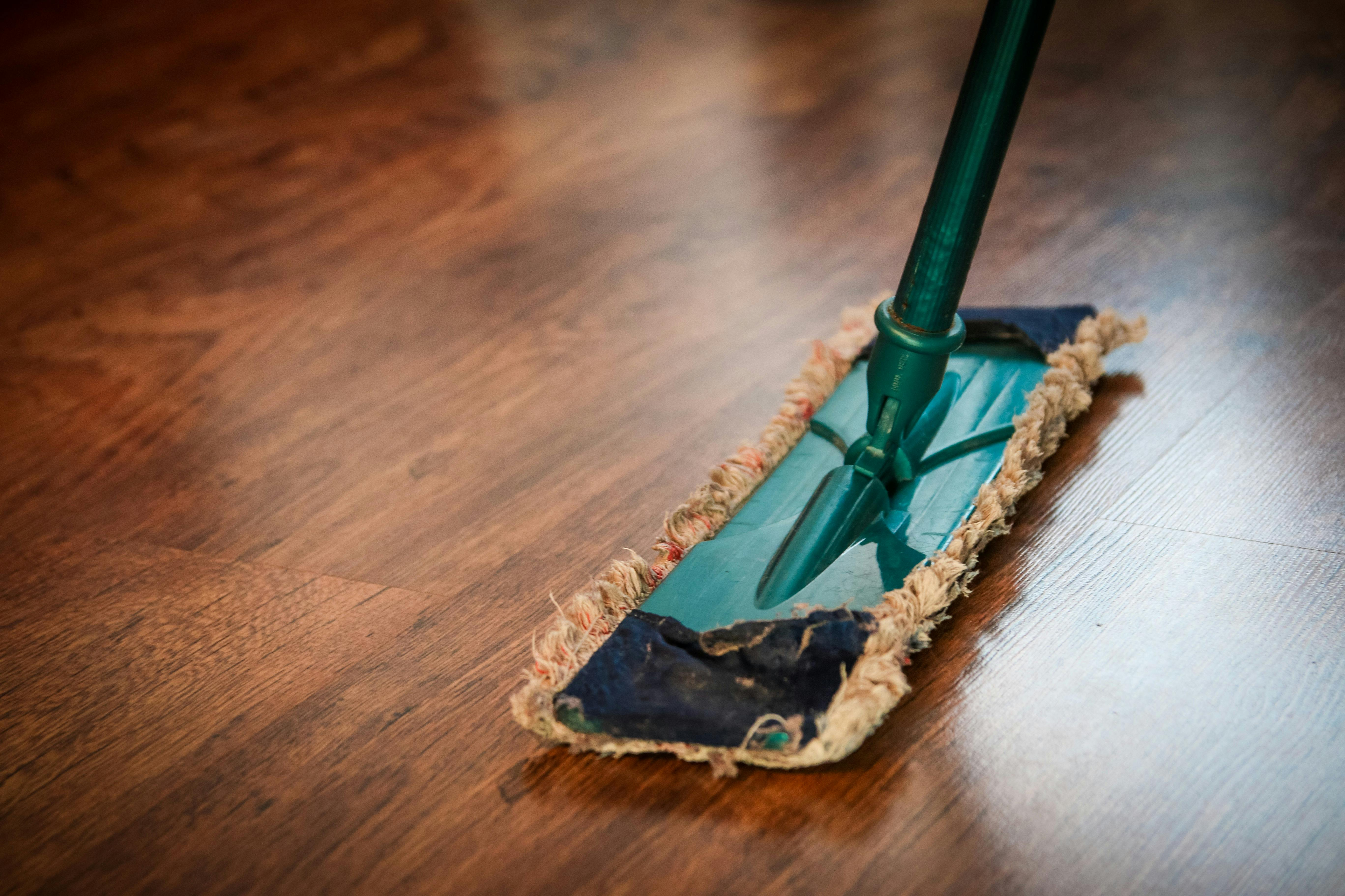 Wood floor being swept with dust mop