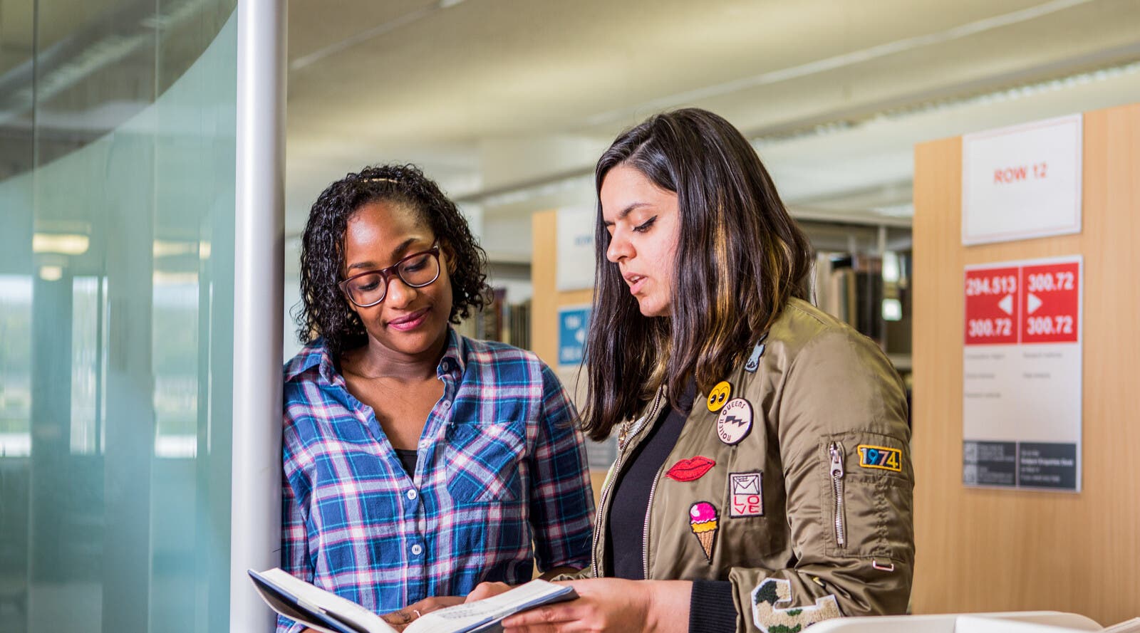 Two students compare notes at the University library
