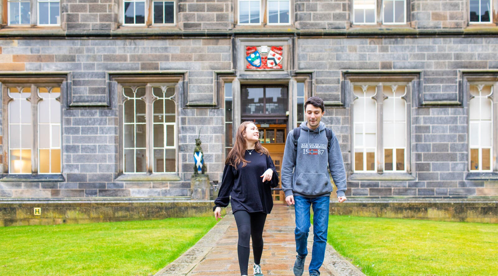 Two students walking around Aberdeen's historic campus