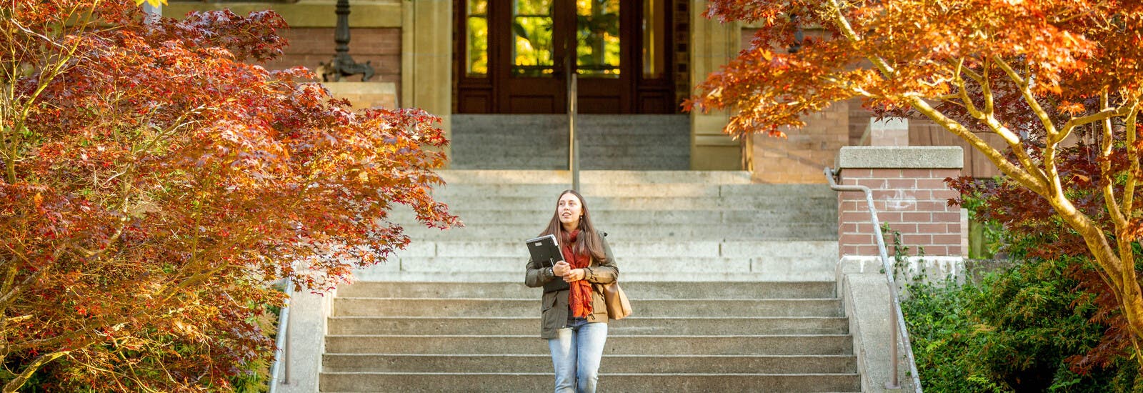 A WWU student walking down steps holding a laptop