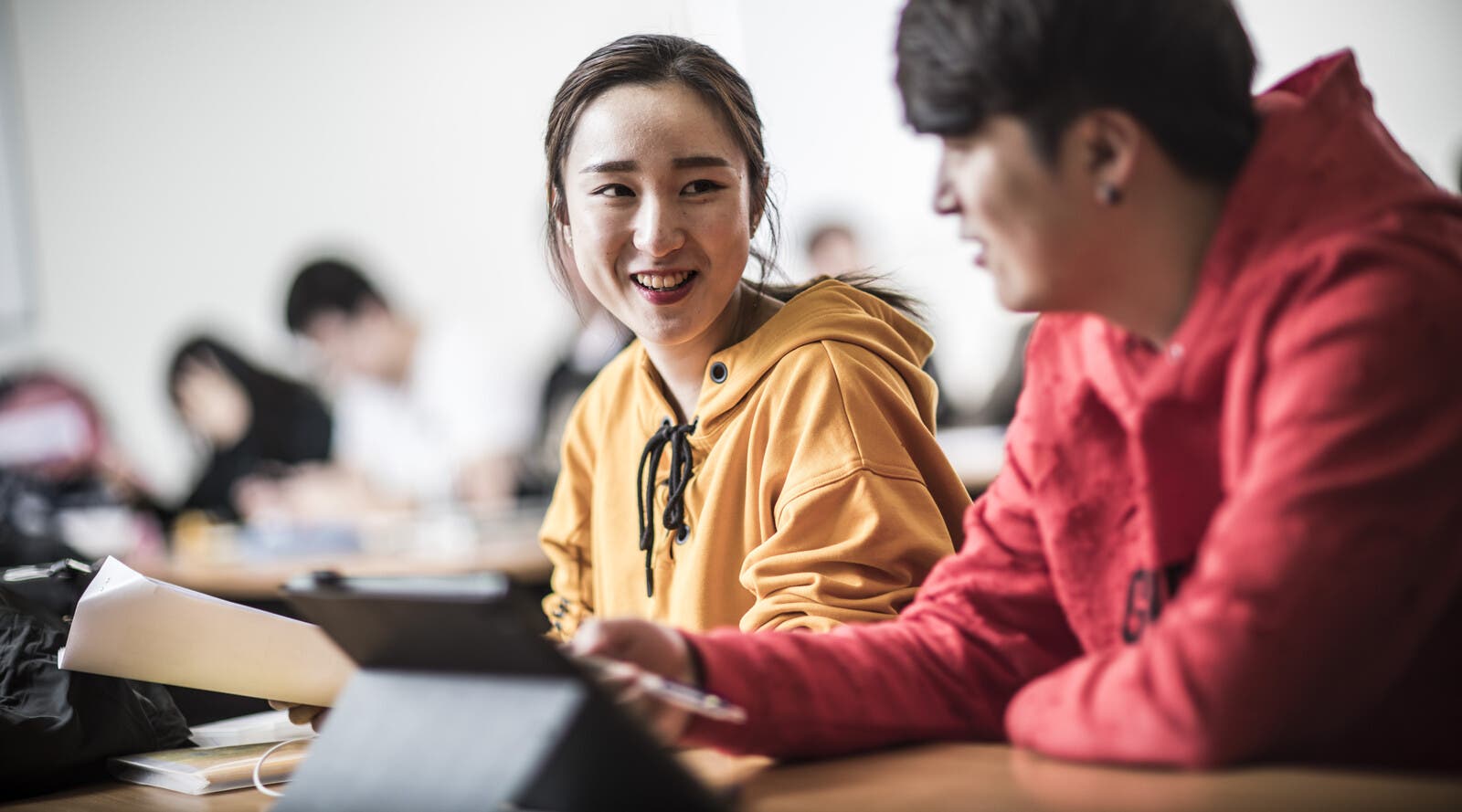 Students smiling and talking in class