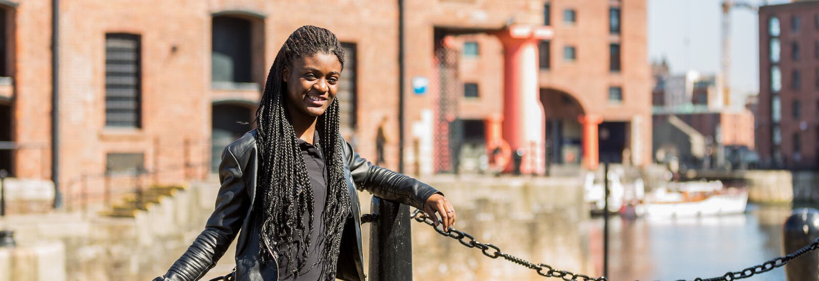 Student leaning against railing in Liverpool