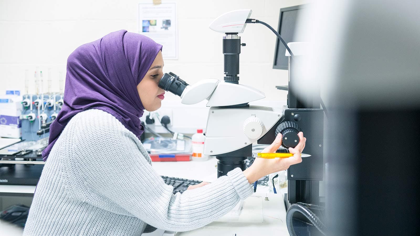 A University of Sussex student using a microscope