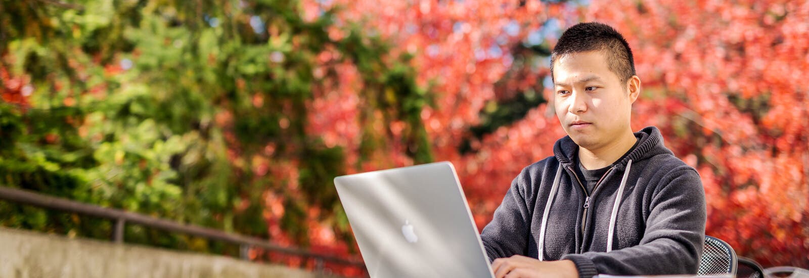 Student working on laptop outside