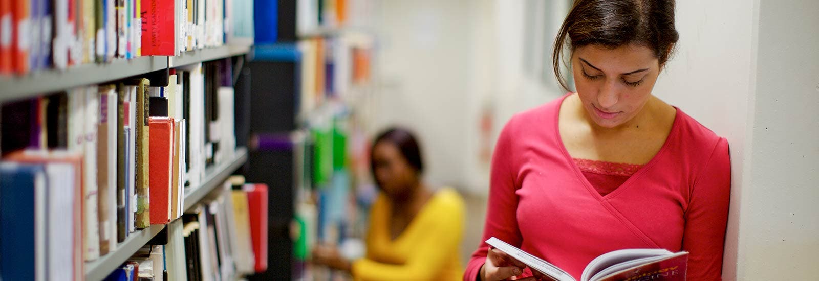 Student reading book in library