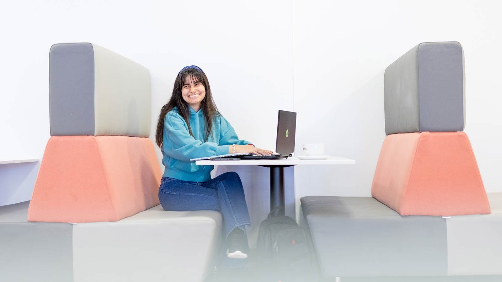 Student smiling and sitting at table in study centre