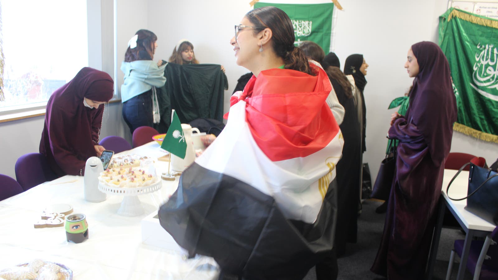A student wrapped in a flag in front of a table with food.