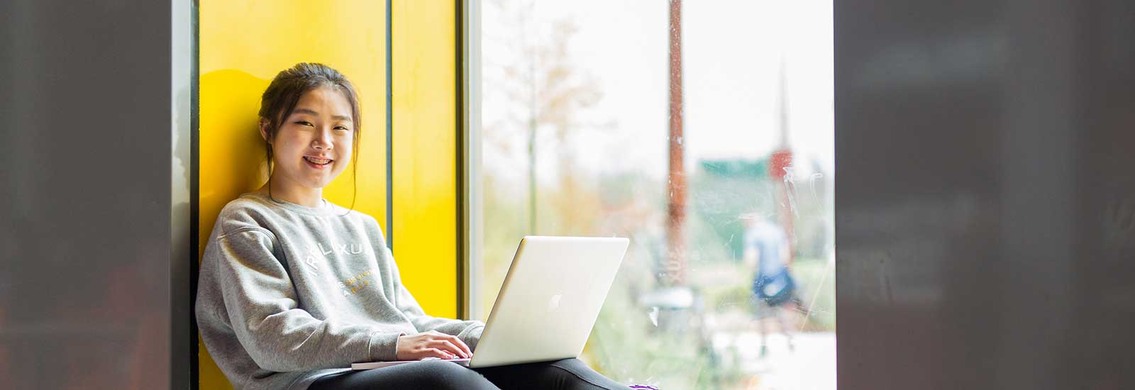 A Dublin ISC student sat on their laptop smiling