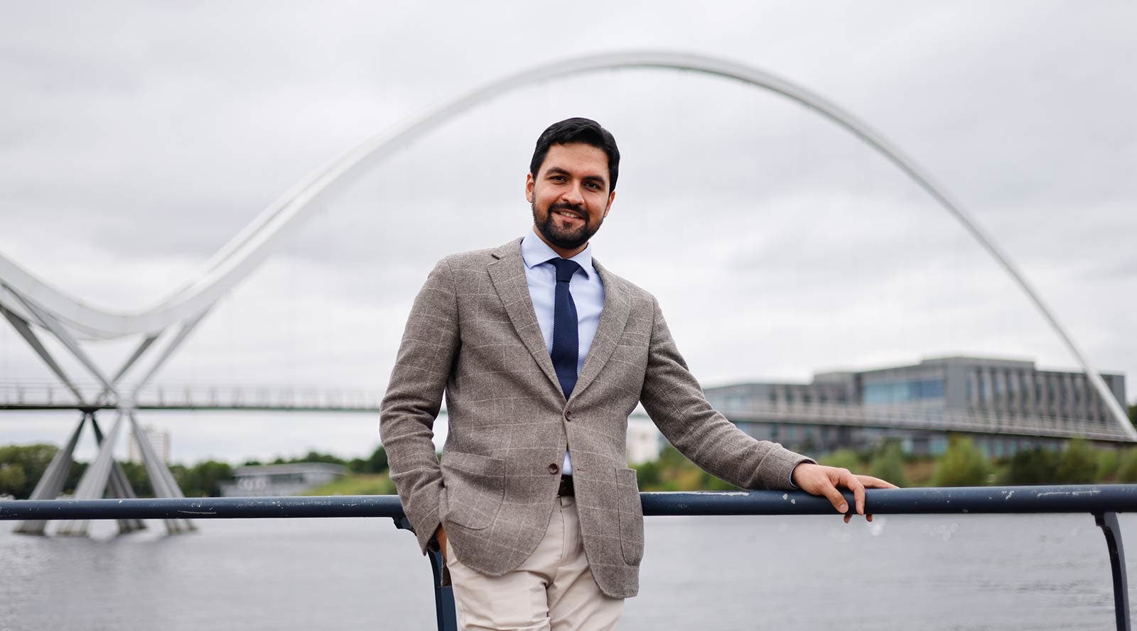 Mustafa, a Durham University student standing on a bridge