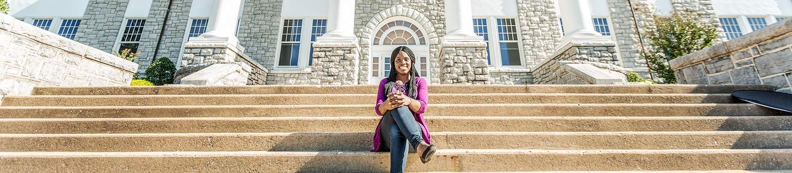 A student sat outside of one of the JMU buildings