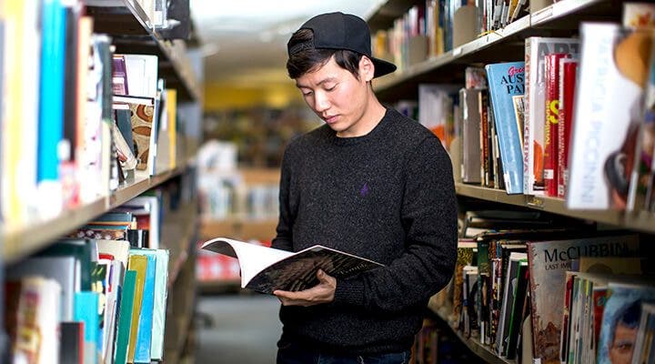 University of Sydney student reading a book in library