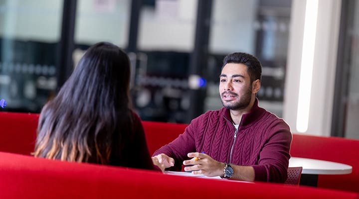 Students talking at a table on campus