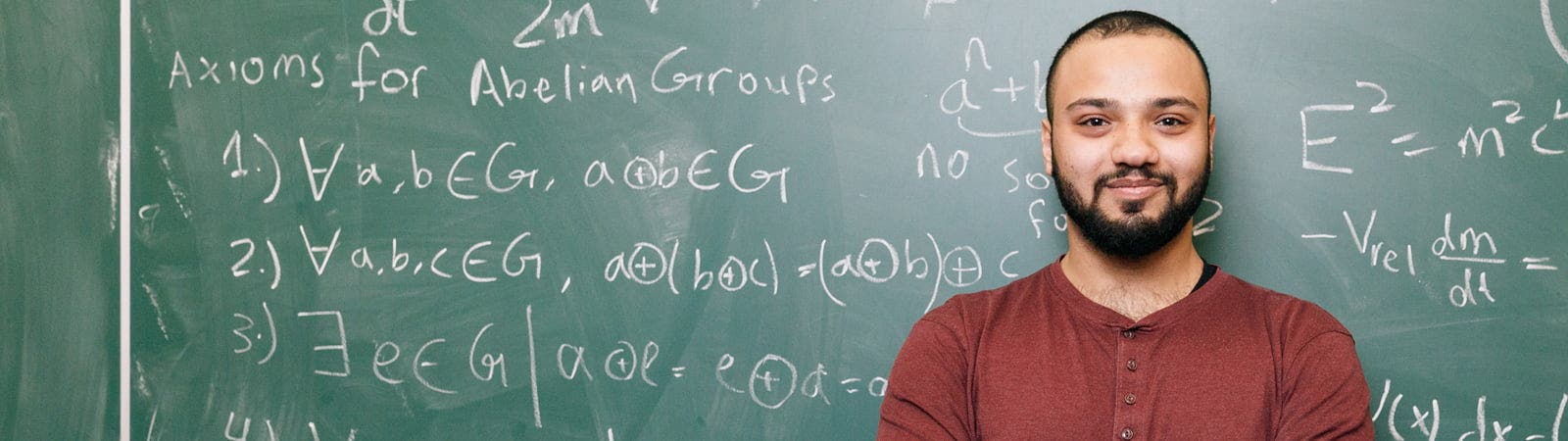 Surrey student standing in front of blackboard