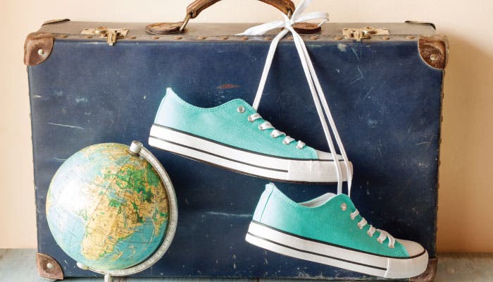 Pair of trainers and globe with a suitcase