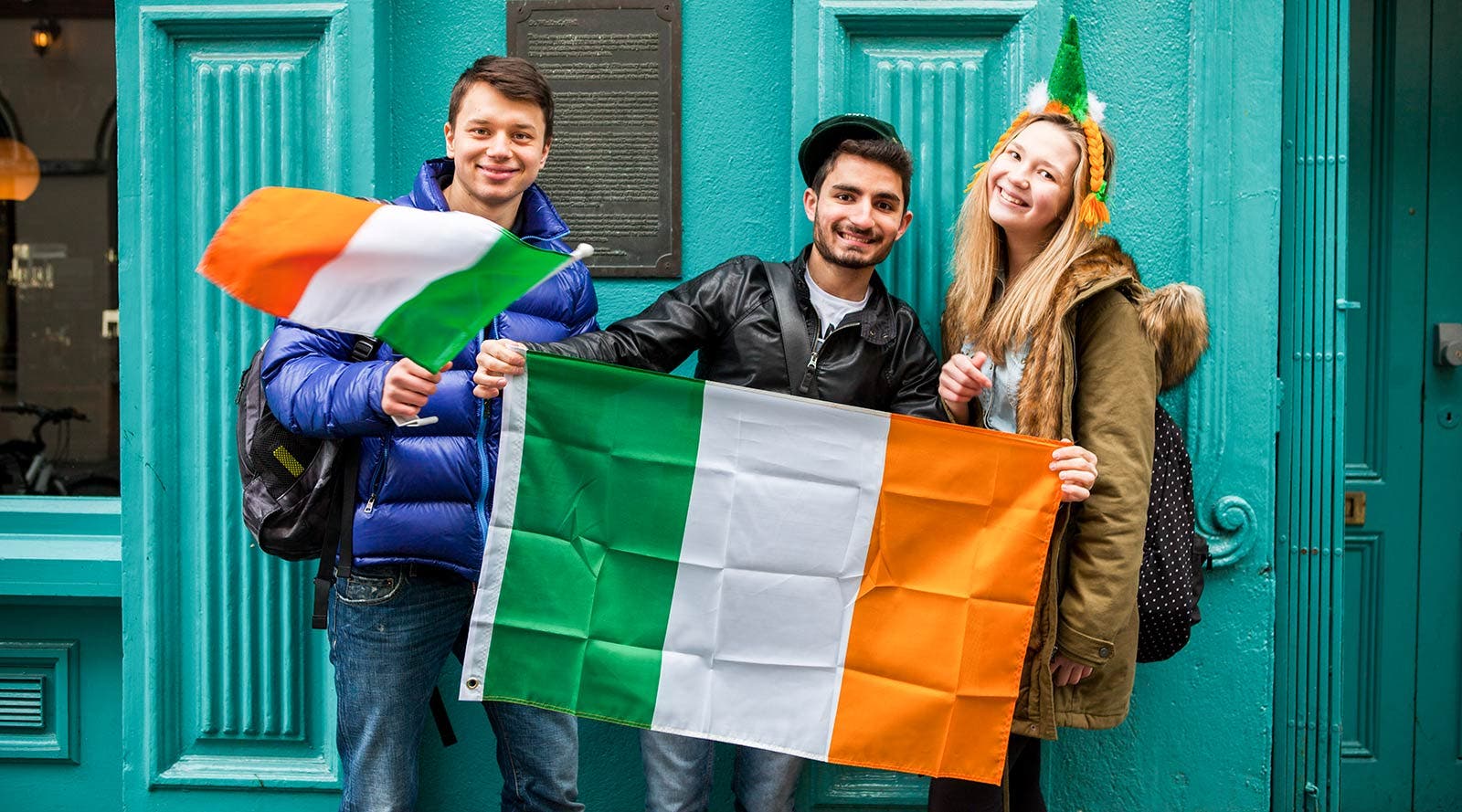 A trio of students smiling on St Patrick's day.