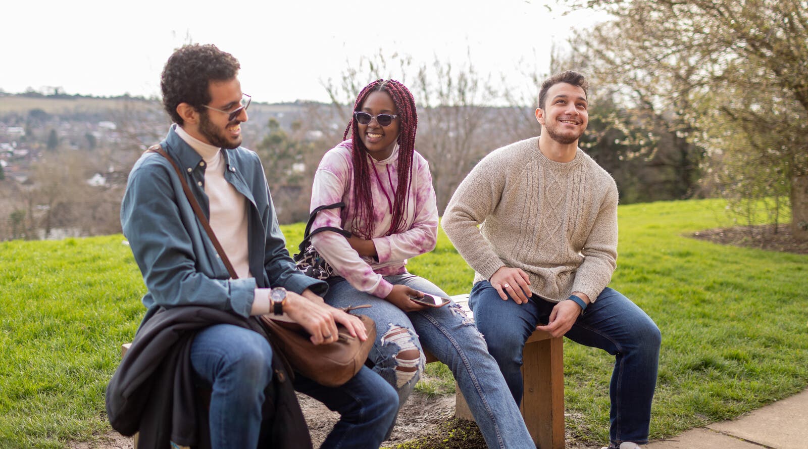 Three international students sat on a bench