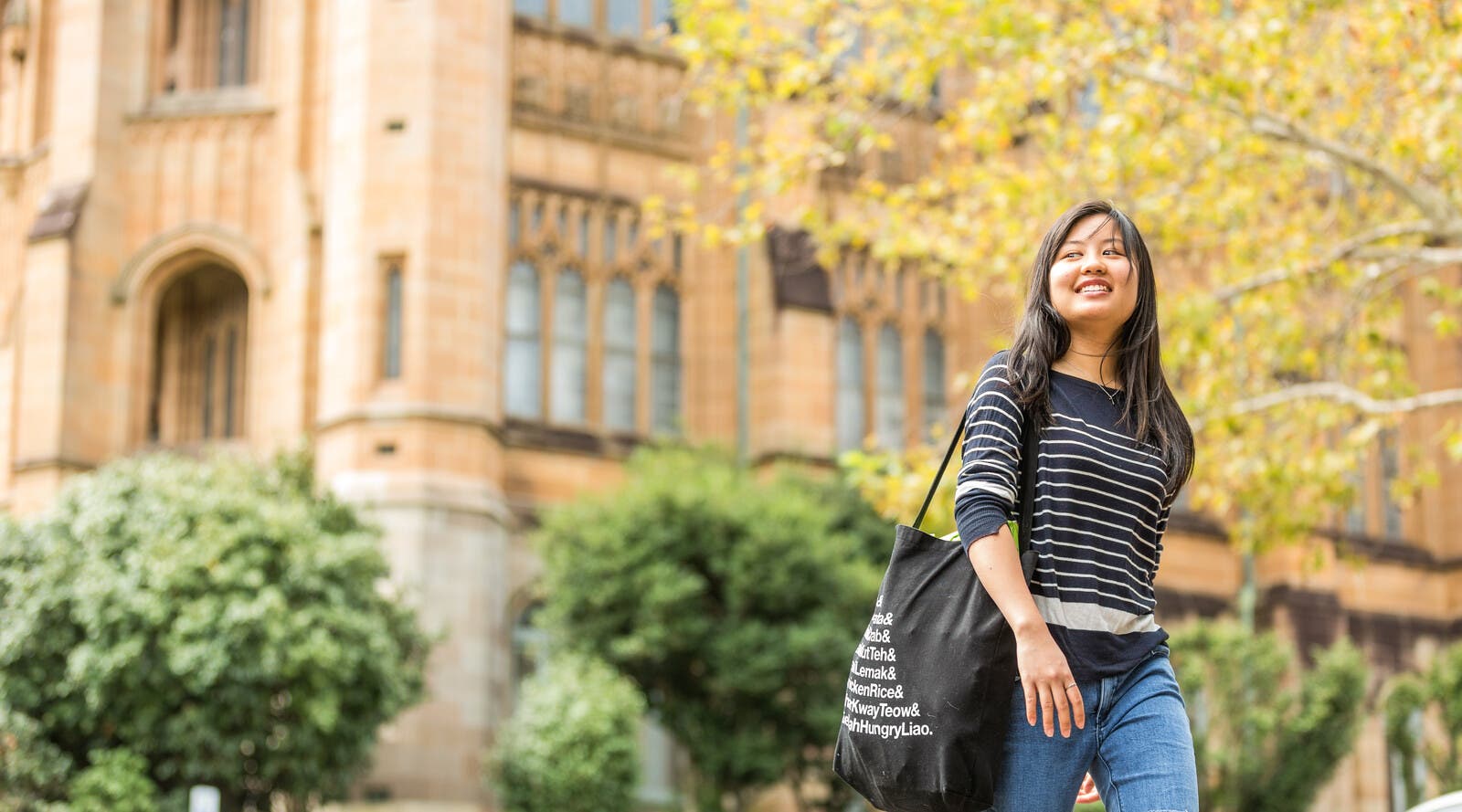 Student smiling and walking outside campus