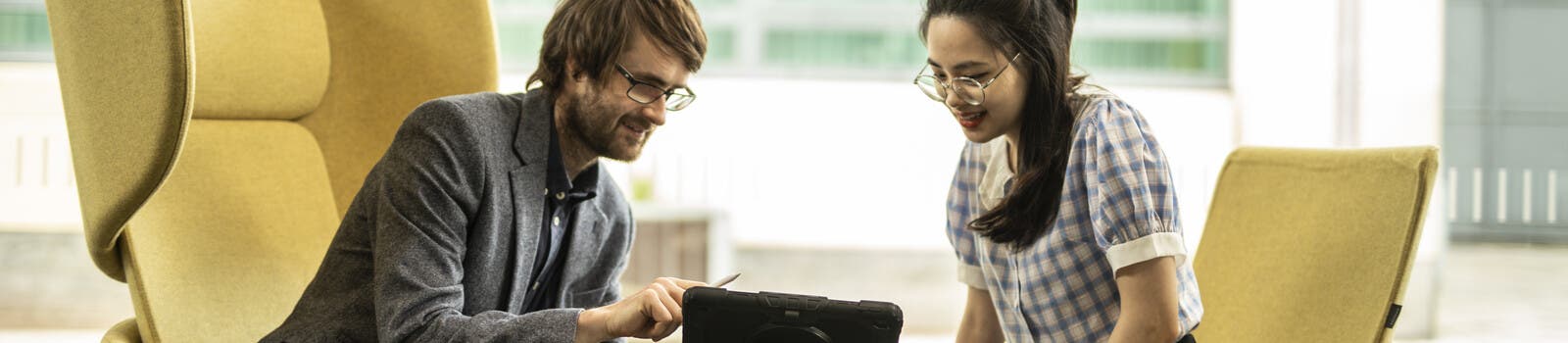 A tutor and a student looking at a tablet together