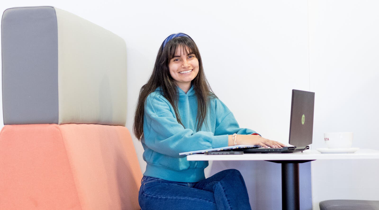 Student smiling and working on laptop