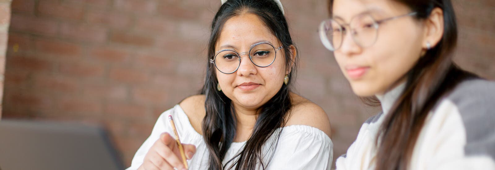 Two students looking at a laptop