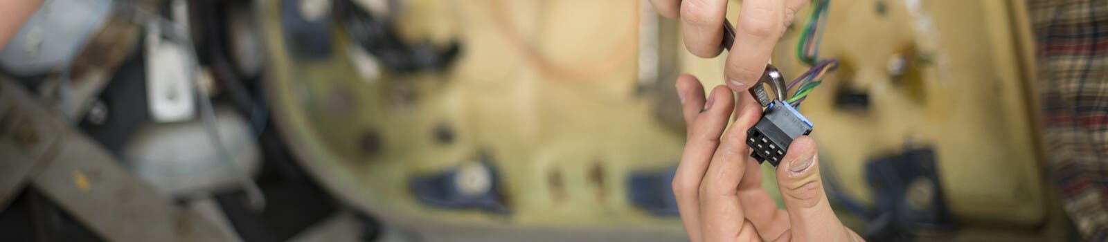 Close up of engineering student using spanner on cable