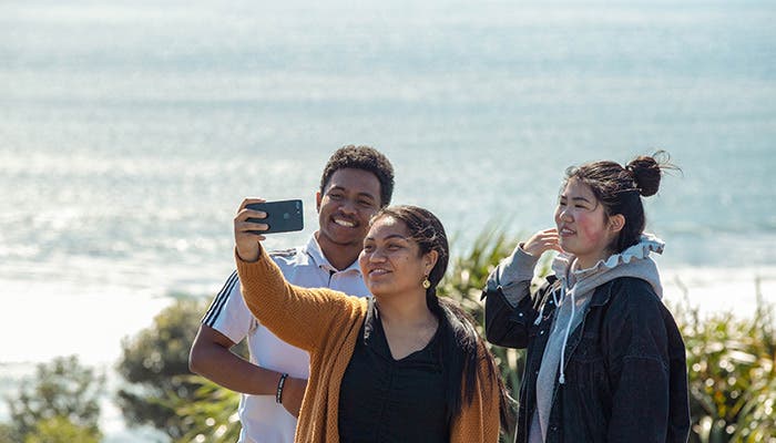 Students taking selfie on beach