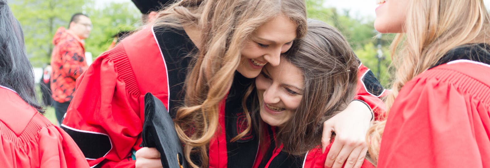 Two students hugging at graduation