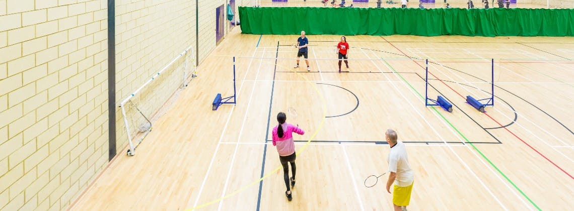 Students playing volleyball in a sports hall