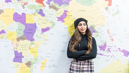Student standing in front of map