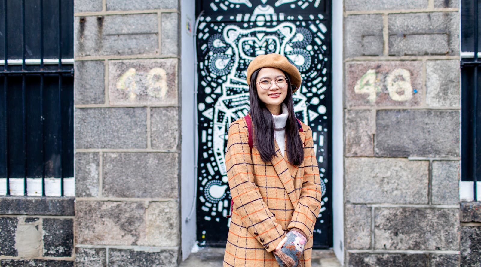 Student smiling in front of decorative door
