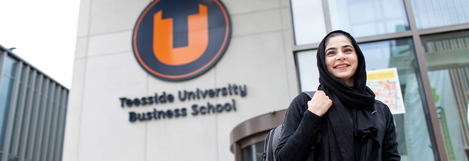 Student smiling in front of Teesside Business School