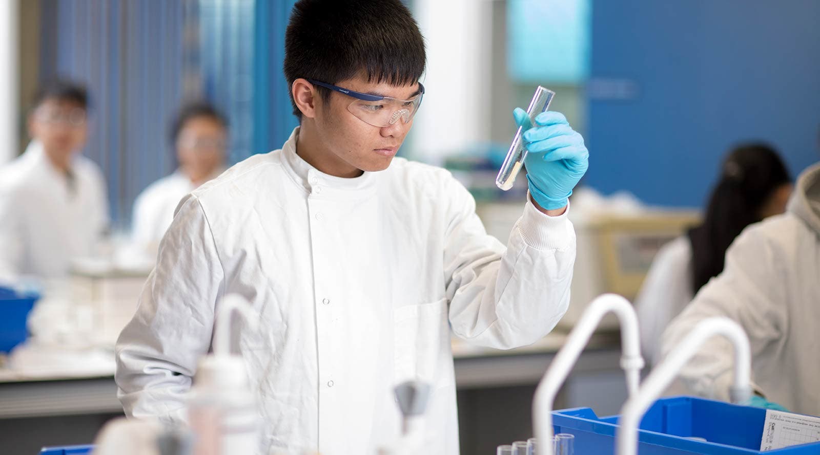Science student in lab holding flask