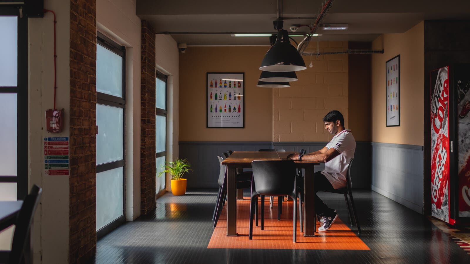 A student sat at a dining table using a laptop