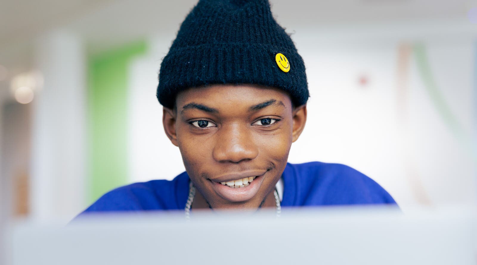 Student smiling and looking at laptop