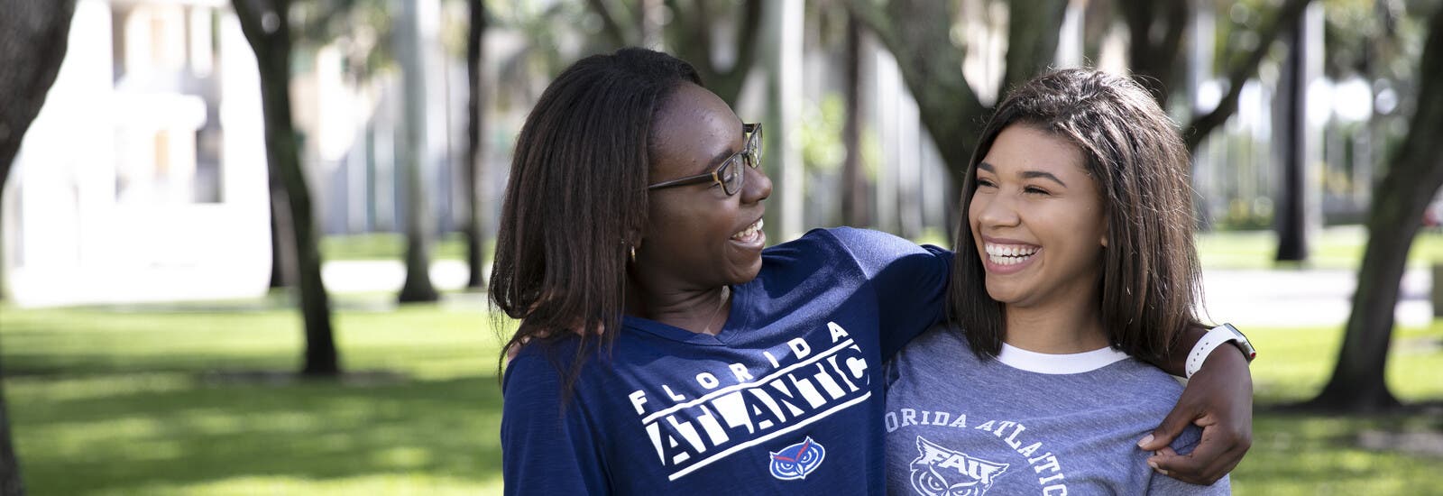 Two students laughing with their arms around each other