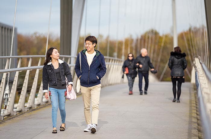 Students walking across a bridge together