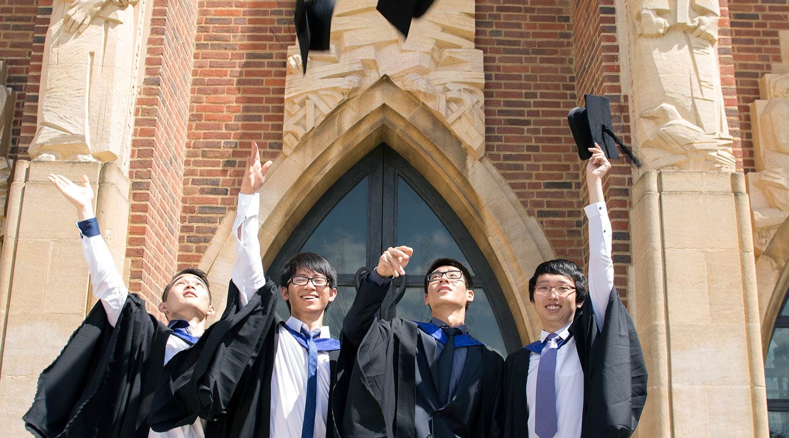 Surrey graduates throwing hats in the air