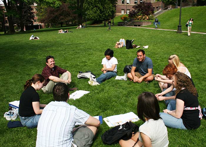 Students sitting on grass and studying together