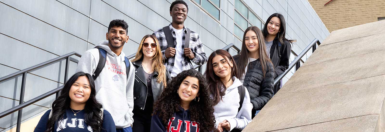 A group of students standing on steps and smiling