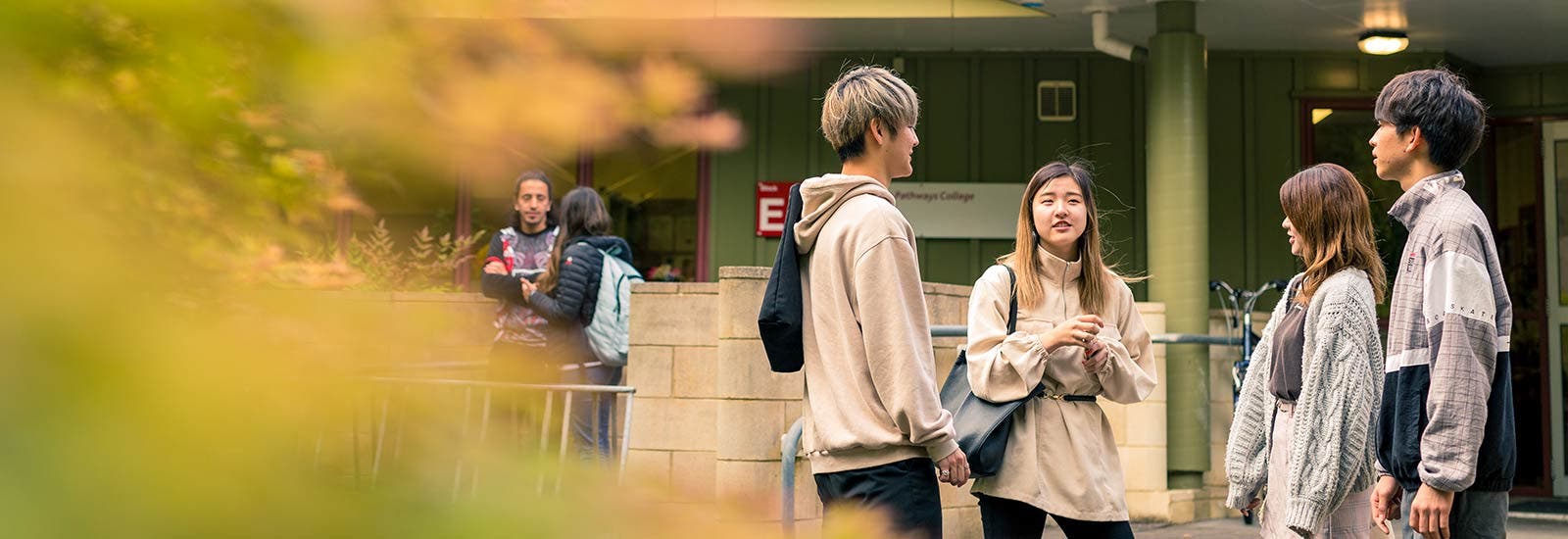 Students standing and talking outside campus