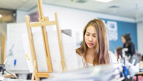 Art student in class using easel