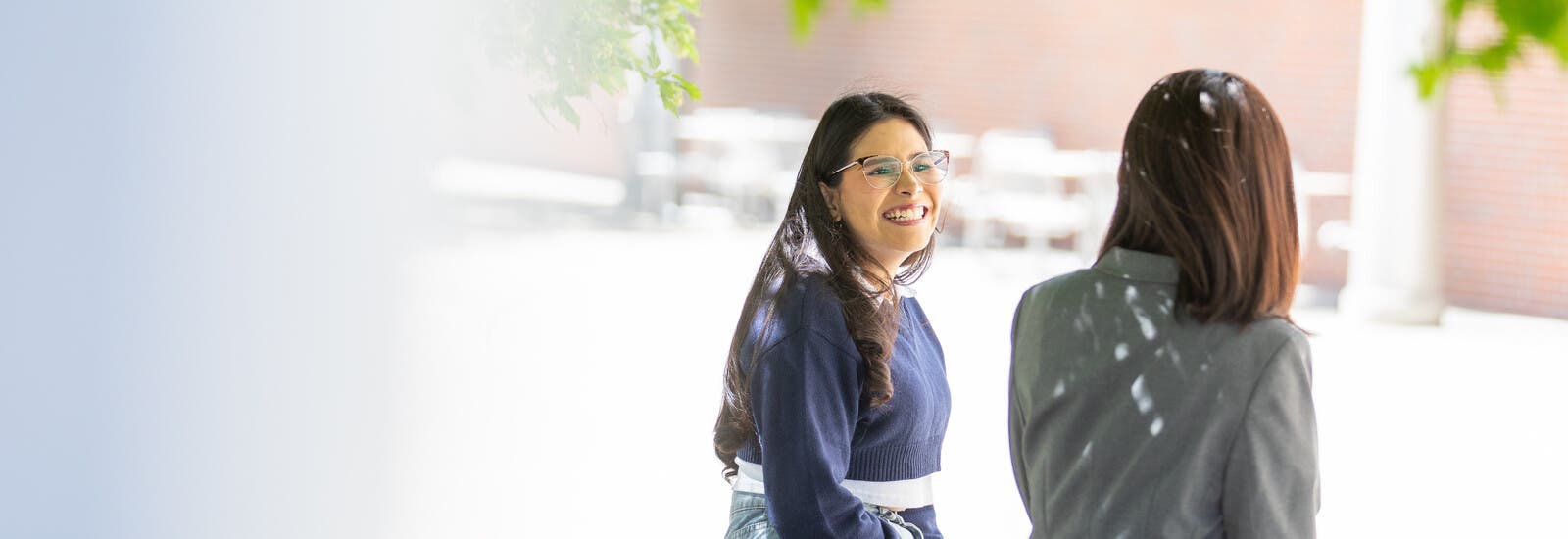 Two students sitting and talking outside campus