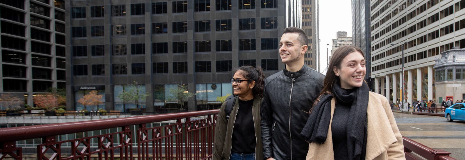 Three students smiling and walking around Chicago