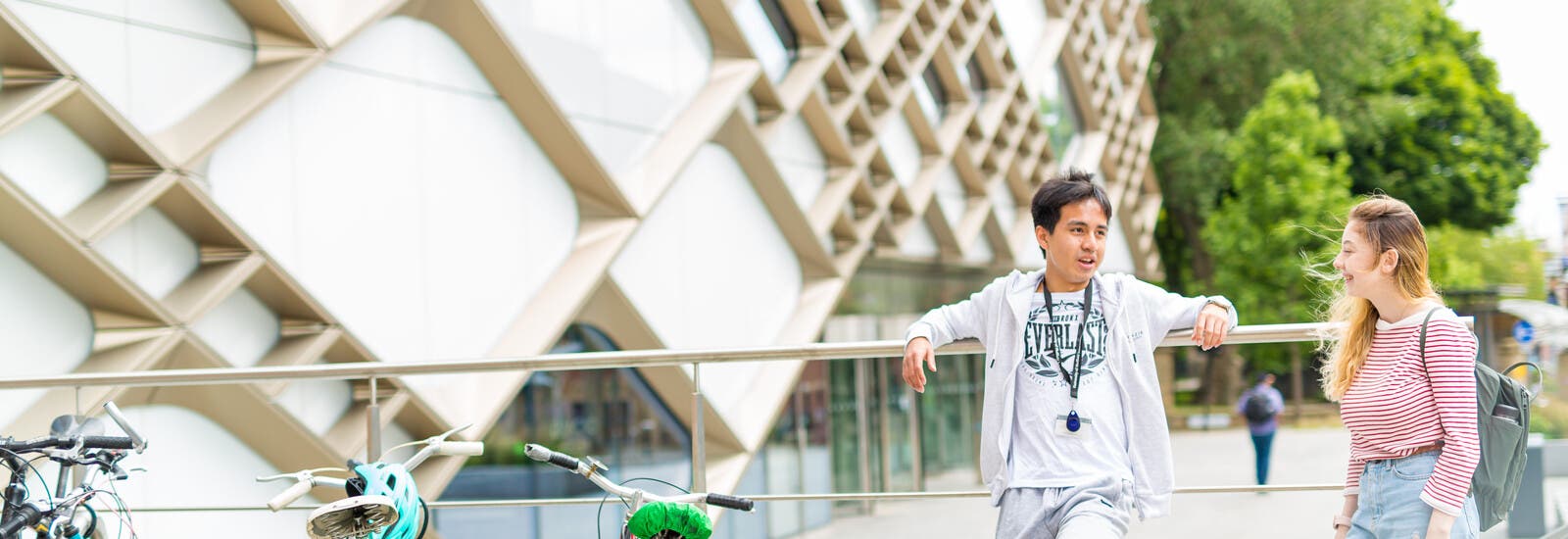 Students leaning on railings outside campus