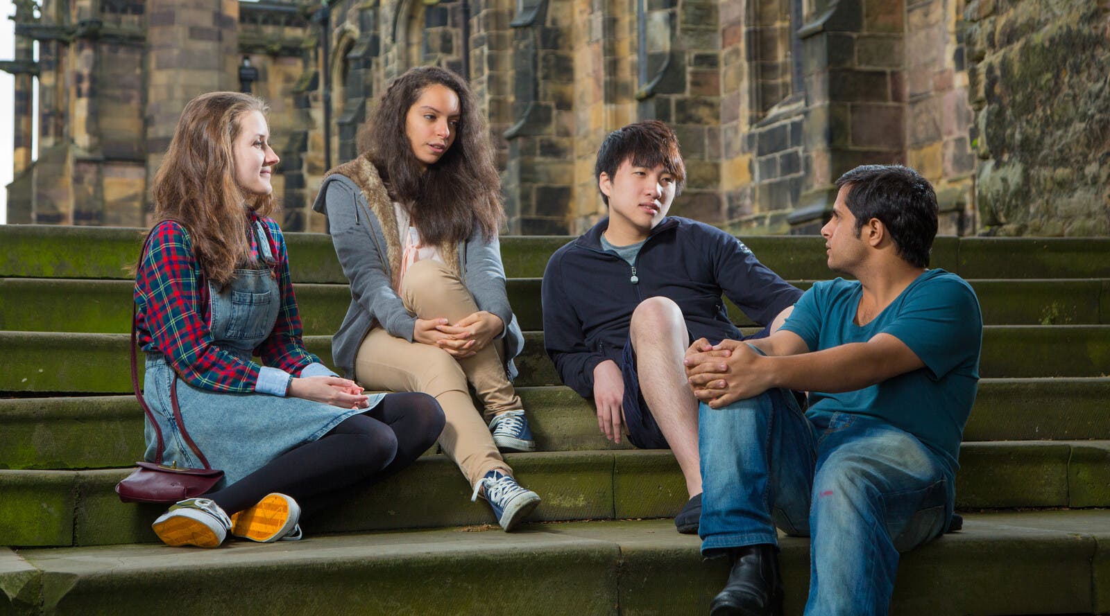 A group of students sit outside talking