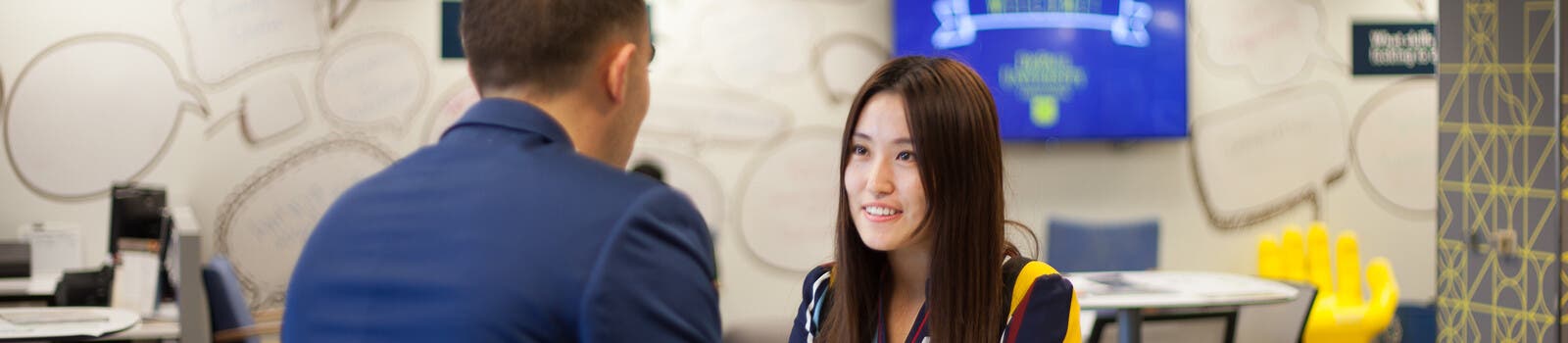 Student talking to tutor on campus