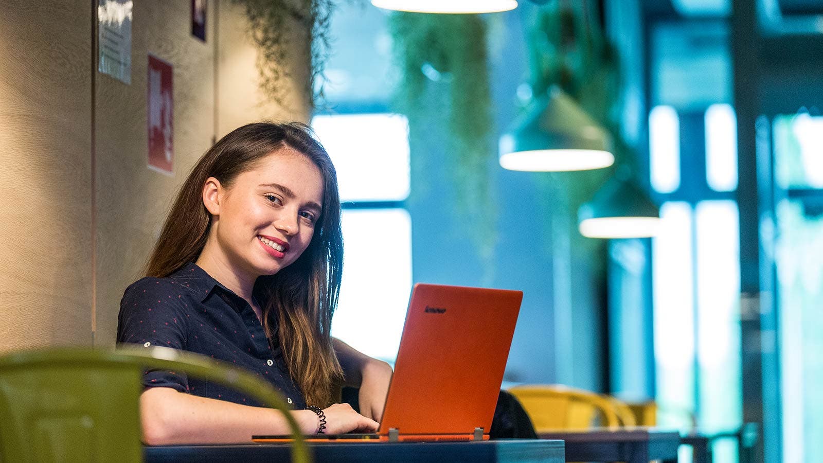 Student smiling and working on laptop