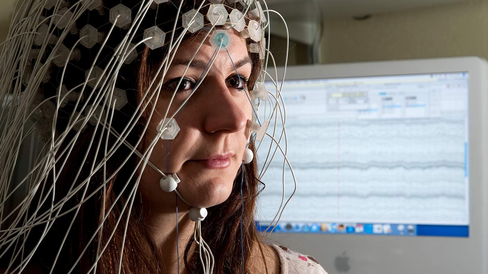 A woman plugged into a brain activity monitoring device