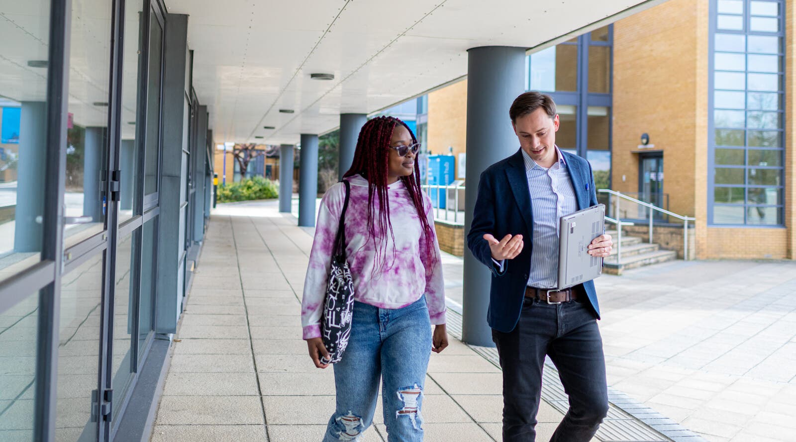Surrey student and tutor walking through campus