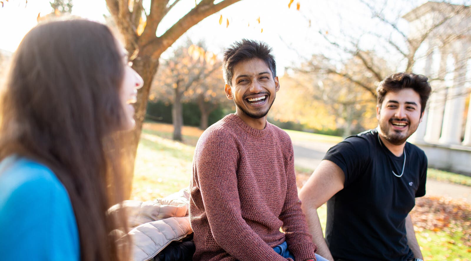 Three students laughing on Cardiff University's campus